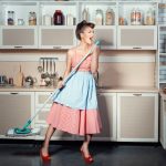 Woman sings and cleans the house.